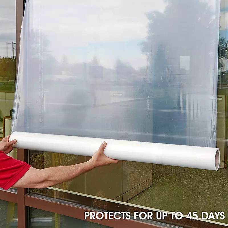 Hands applying protective window film roll with 45-day protection claim