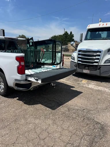 Pickup truck and semi-truck parked together on asphalt parking lot