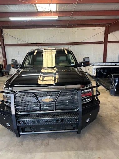 Black Chevrolet truck with heavy-duty grille guard in workshop