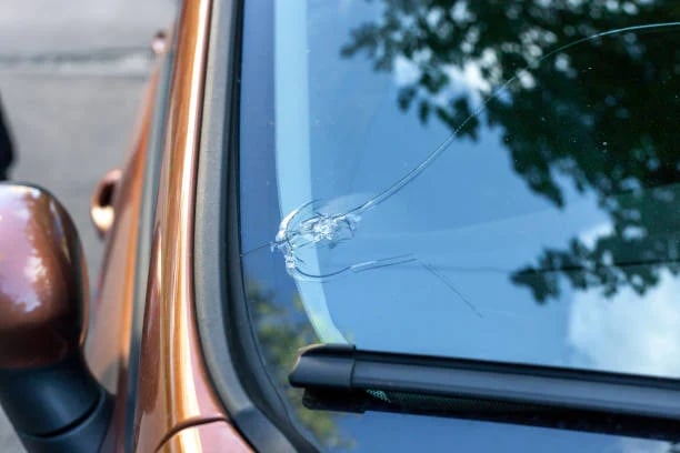 Cracked car window with spider web-like fracture pattern